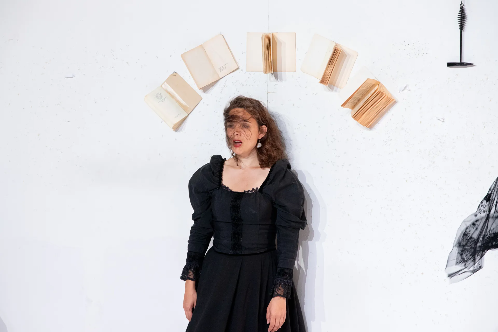 Festival di Spoleto performer in black dress surrounded by floating books