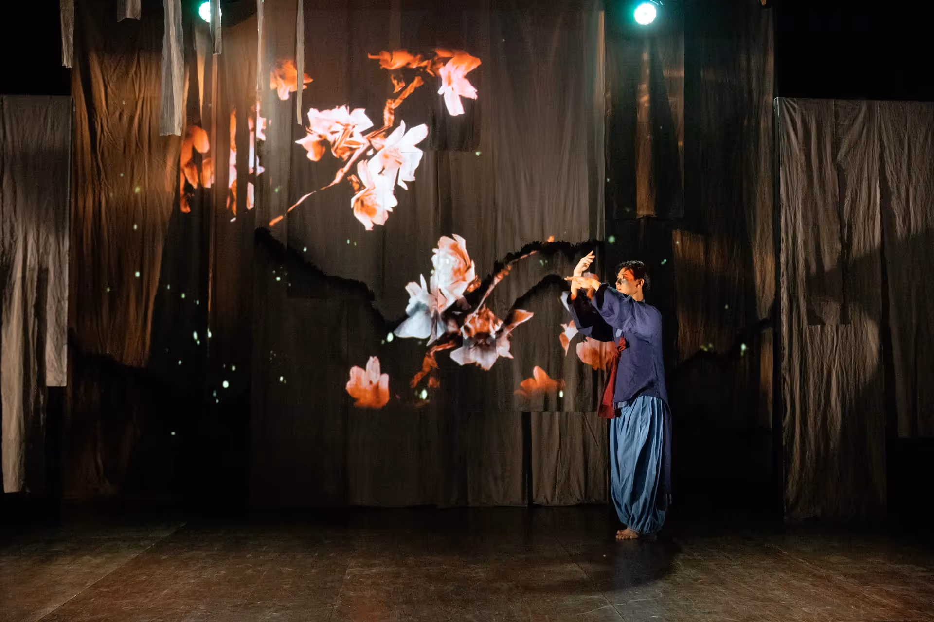 Performer interacts with digital flower projections at Festival di Spoleto performance