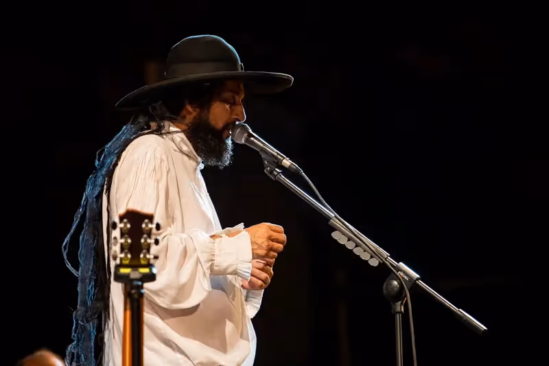 Artista folk si esibisce al Festival di Spoleto con cappello e camicia bianca