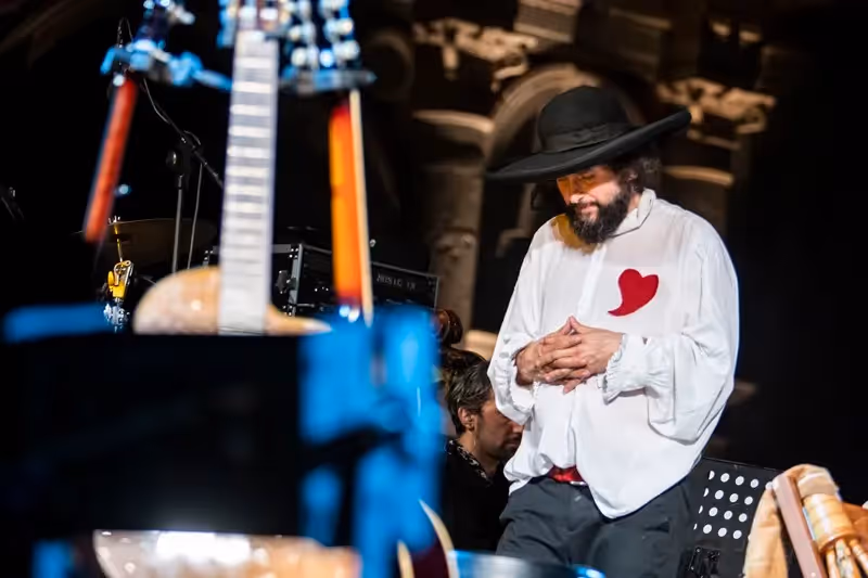 Artista con cappello e cuore rosso sul palco del Festival di Spoleto
