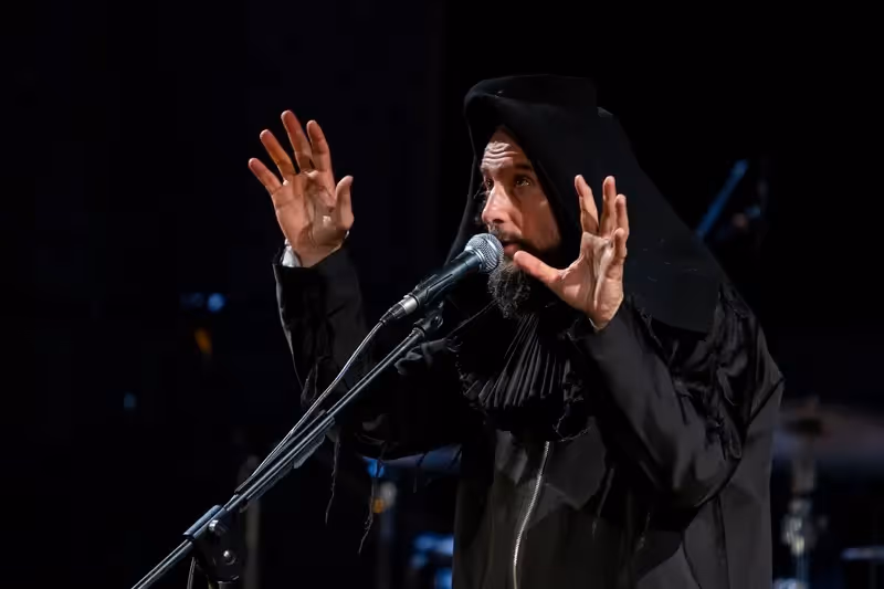 Artista in abito nero si esibisce al Festival di Spoleto con gesti espressivi