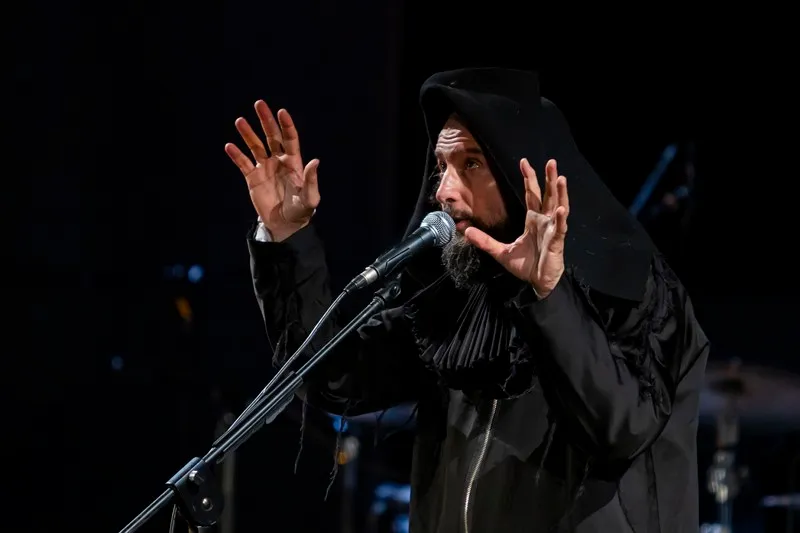 Artista in abito nero si esibisce al Festival di Spoleto con gesti espressivi