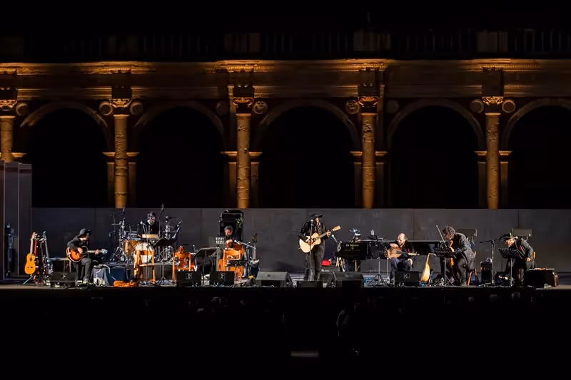 Concerto serale al Festival di Spoleto con musicisti su palcoscenico architettonico