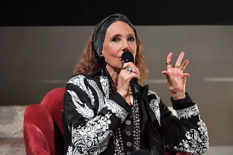 Performer speaks at Festival di Spoleto, wearing black and white ornate jacket