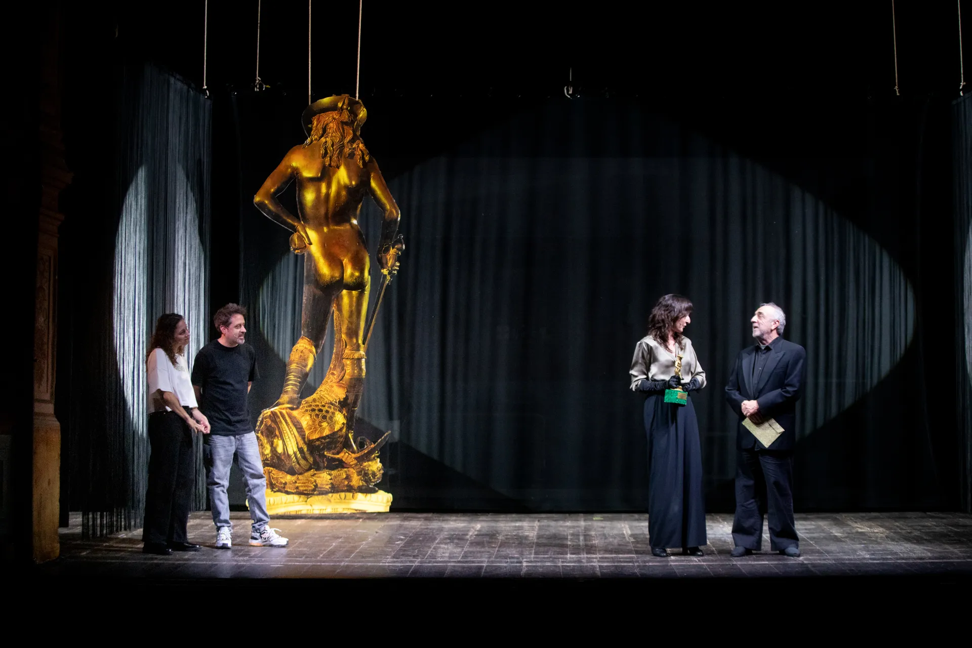 Golden statue and performers at Festival di Spoleto theatrical stage production