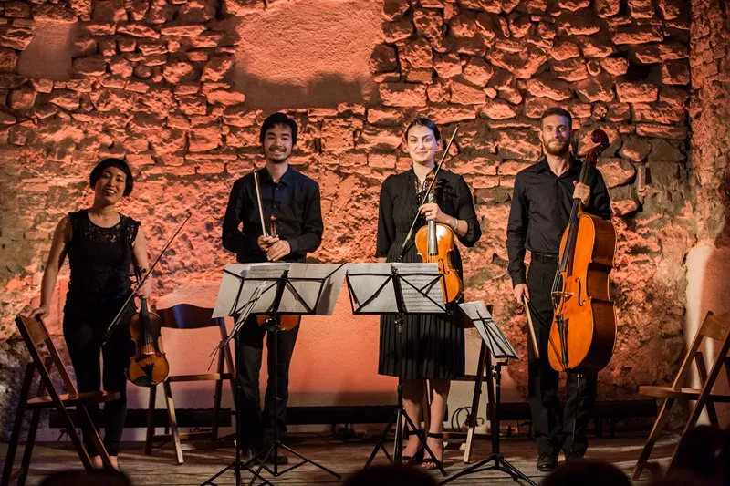 Classical quartet performs at Festival di Spoleto against rustic stone wall backdrop