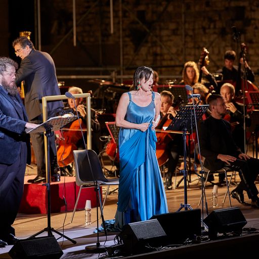 Concerto al Festival di Spoleto con cantante in abito blu e orchestra