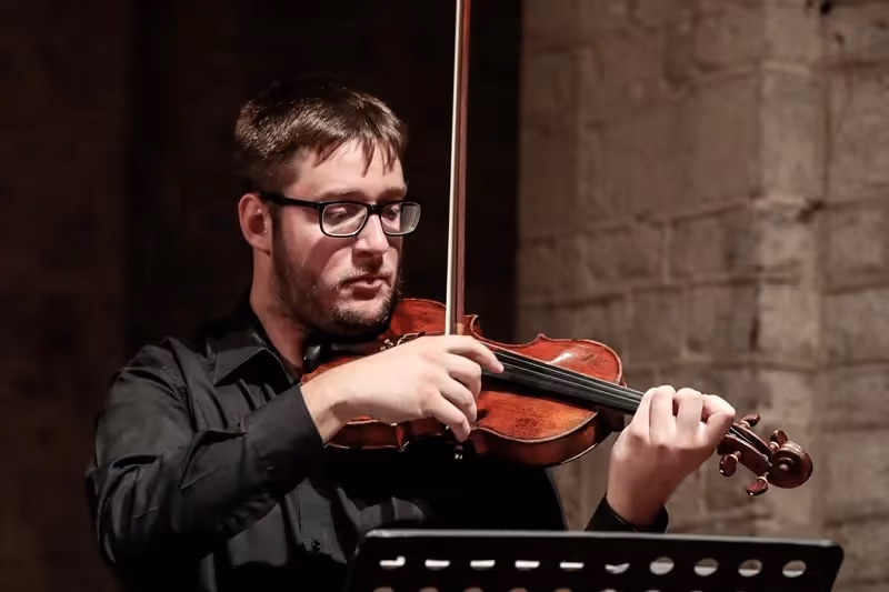Violinist performing at Festival di Spoleto, focused and intense during concert