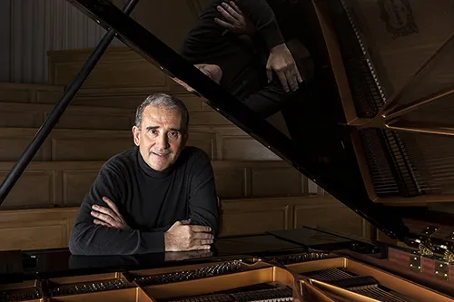 Musicista al pianoforte durante il Festival di Spoleto, sorridente e riflessivo