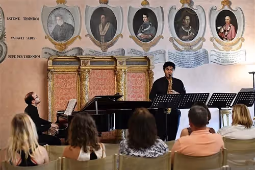 Esibizione musicale al Festival di Spoleto, con ritratti storici alle spalle