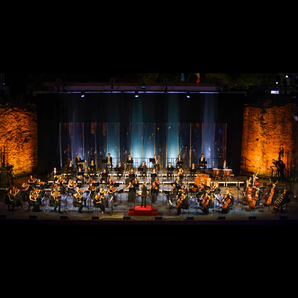 Festival di Spoleto orchestra performing in dramatic stone-walled concert hall