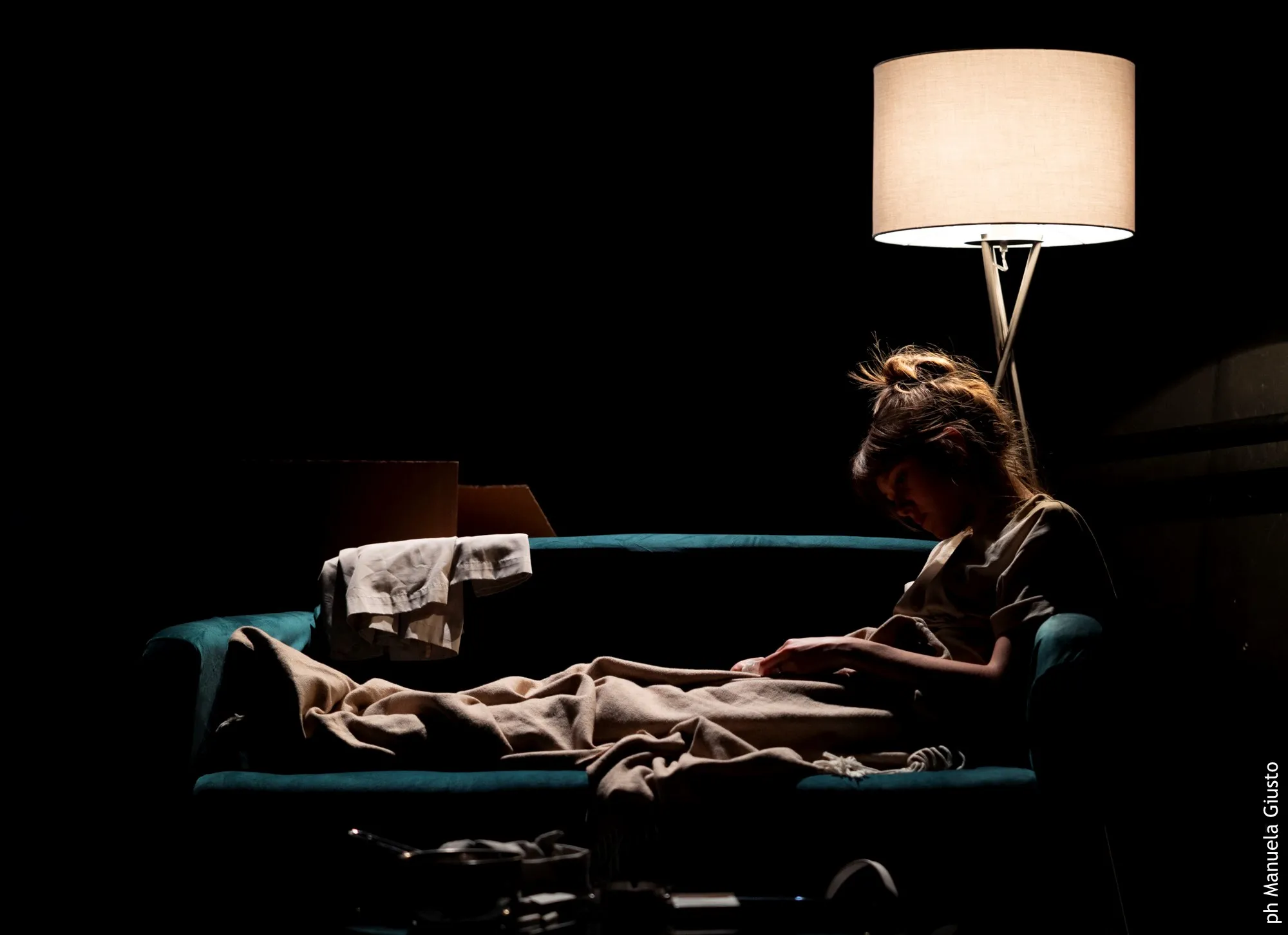 Performance intima al Festival di Spoleto, donna riposa sotto la luce soffusa