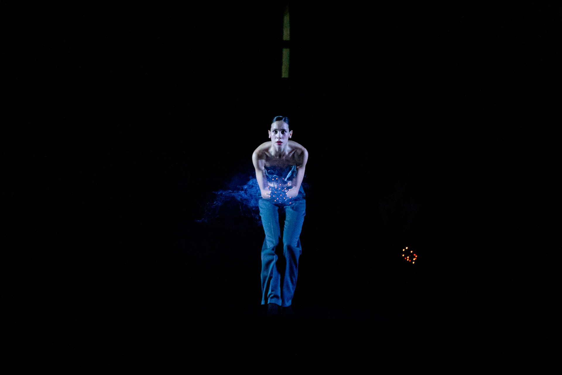Ballerina sospesa nel buio al Festival di Spoleto, luce blu drammatica
