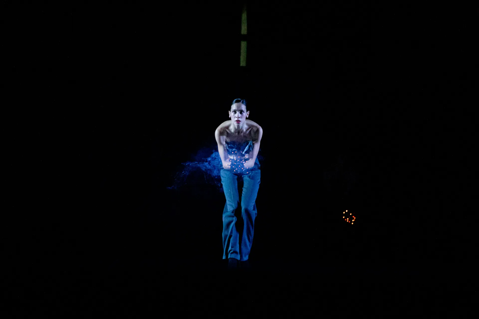 Ballerina sospesa nel buio al Festival di Spoleto, luce blu drammatica