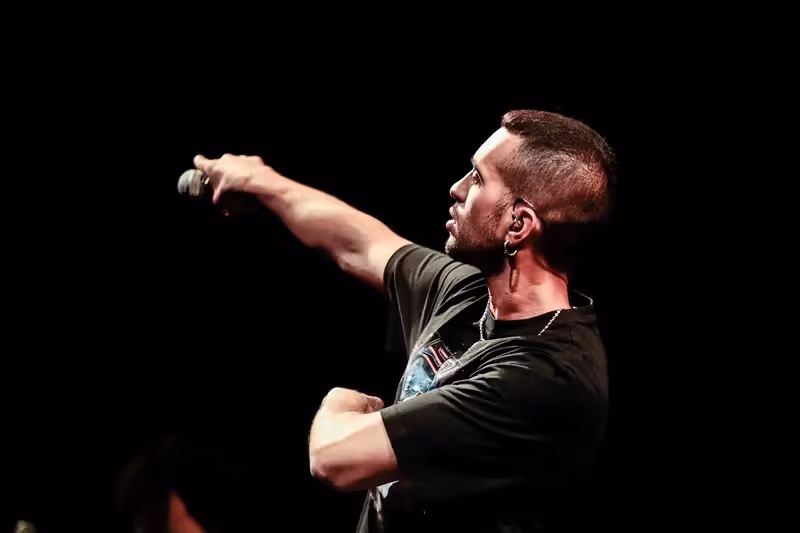 Performer on stage during Festival di Spoleto, passionately singing with outstretched arm