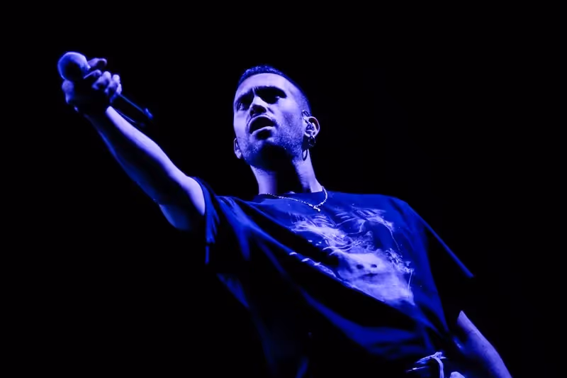 Performer singing passionately at Festival di Spoleto in intense blue lighting