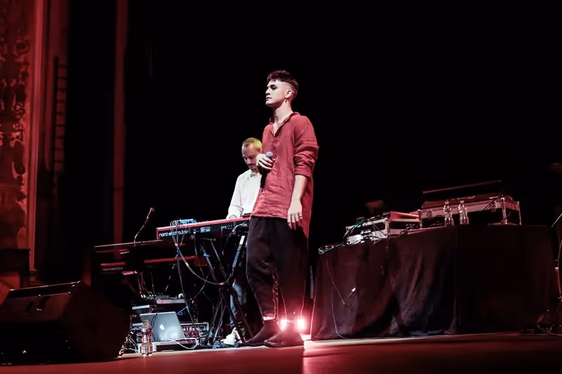 Festival di Spoleto performance with electronic musician on dramatic red-lit stage