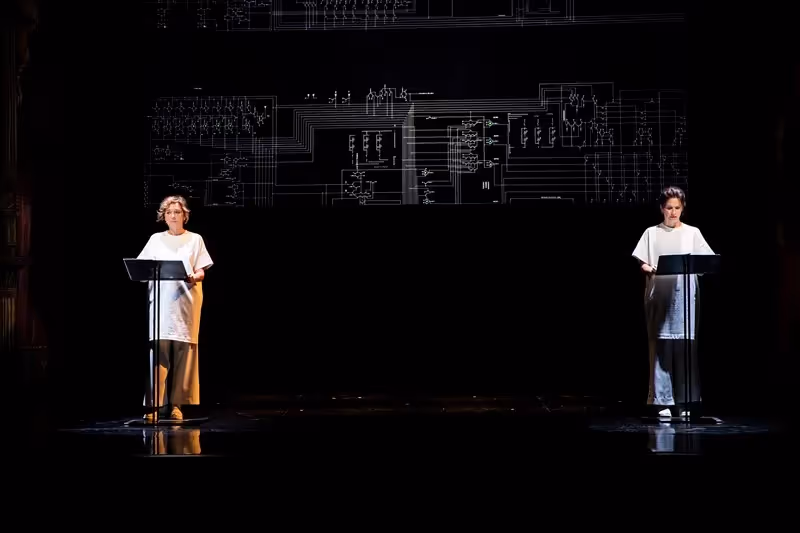 Performers at Festival di Spoleto with circuit diagram backdrop, minimalist stage design