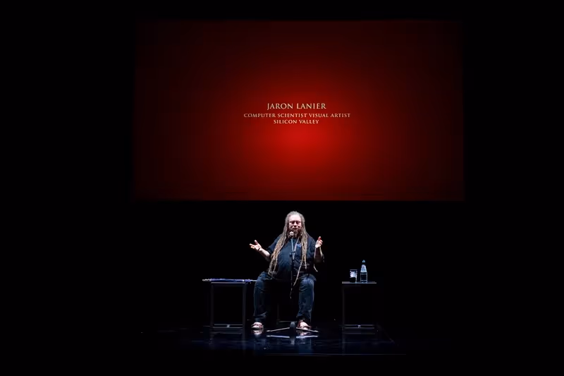 Jaron Lanier speaking at Festival di Spoleto, seated on minimalist stage