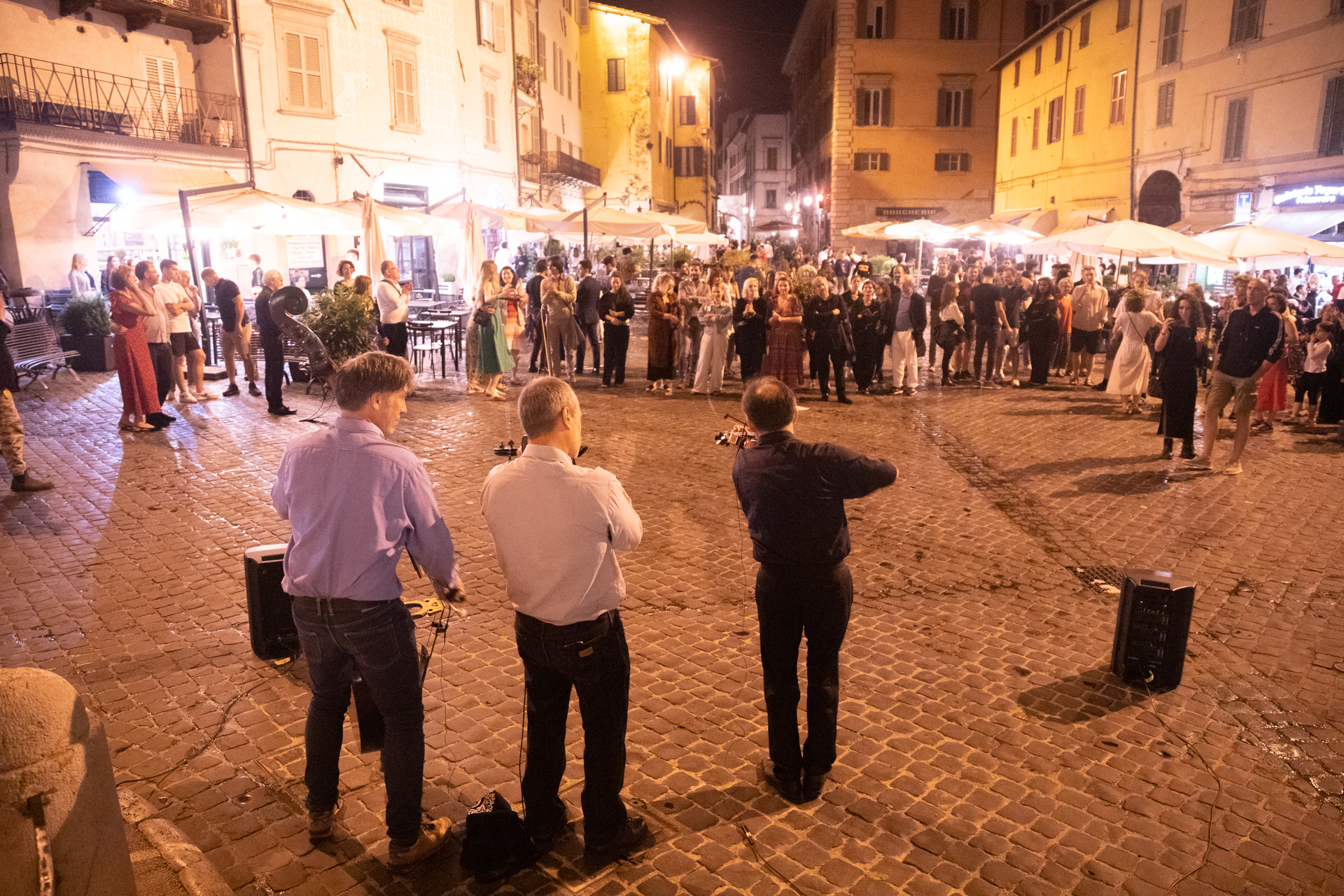 Nighttime scene at Festival di Spoleto with crowded cobblestone square