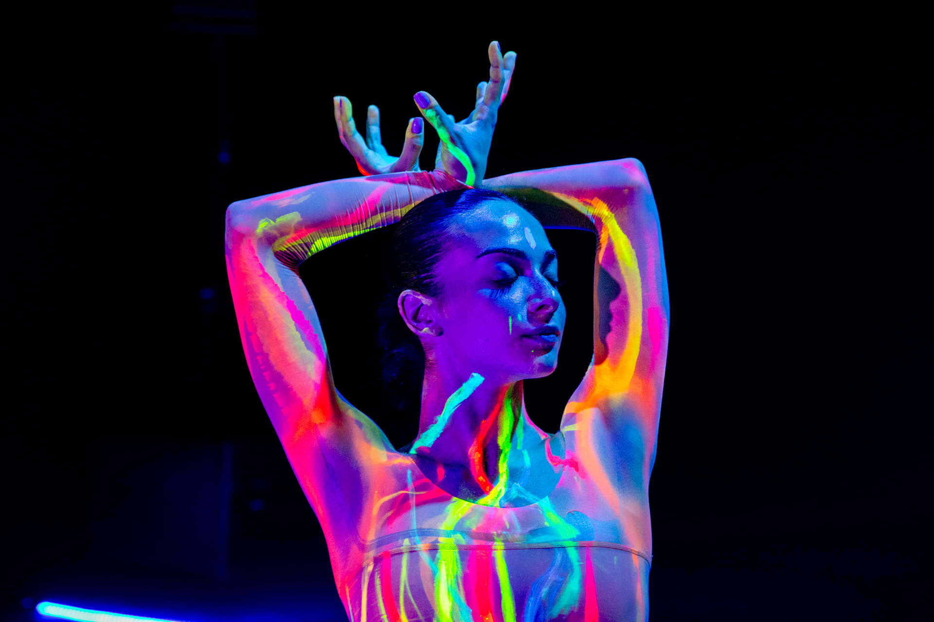 Performance colorata al Festival di Spoleto, danza con luce ultravioletta