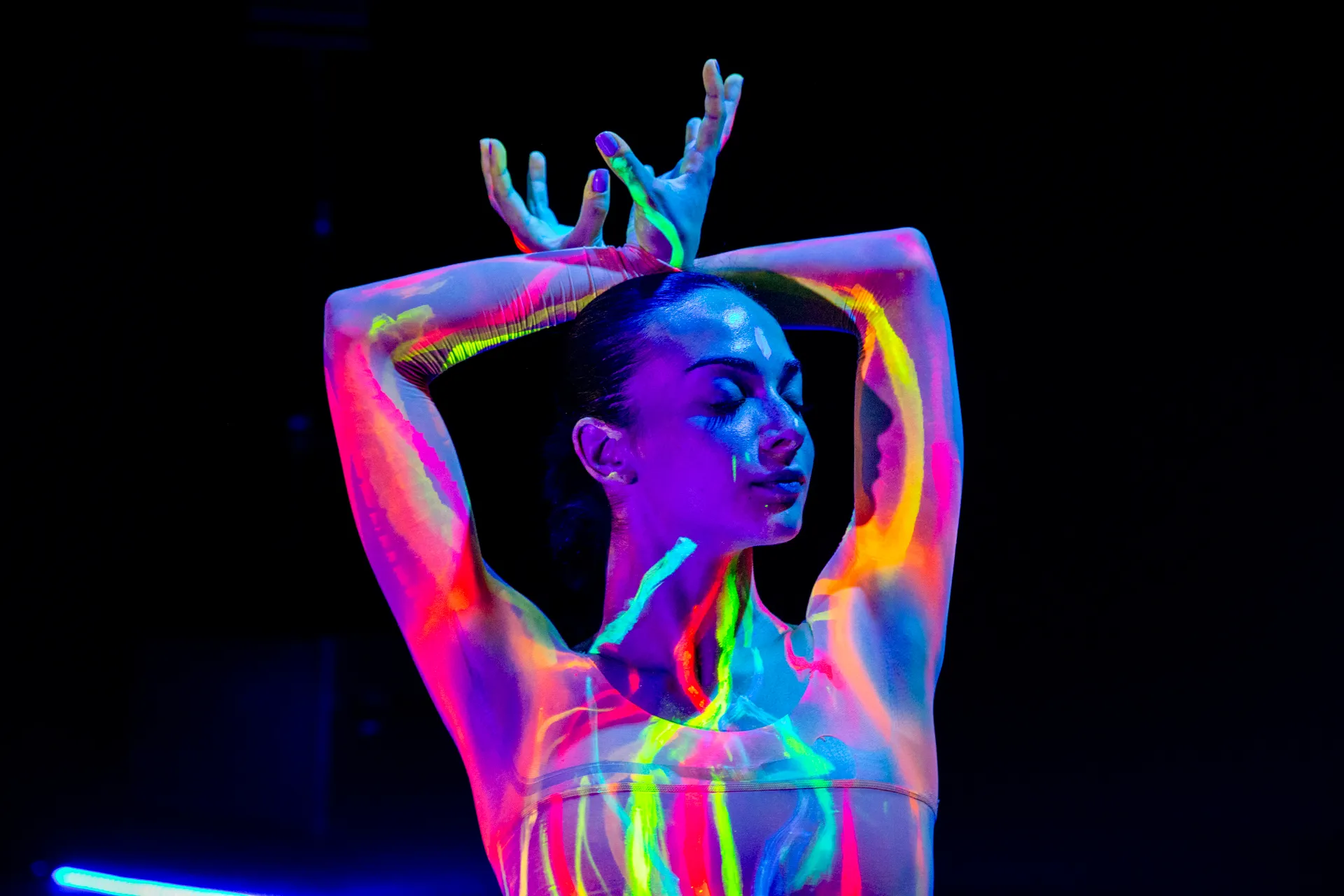 Performance colorata al Festival di Spoleto, danza con luce ultravioletta