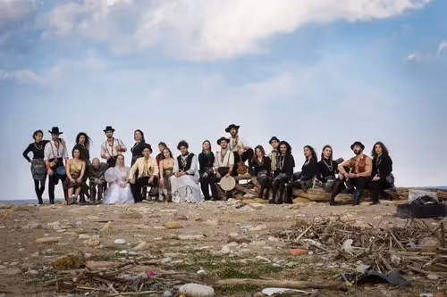 Large group posing at Festival di Spoleto against rocky landscape and sky