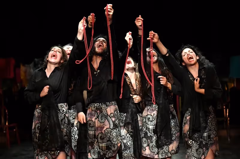 Festival di Spoleto performers in black and patterned costumes with red beads