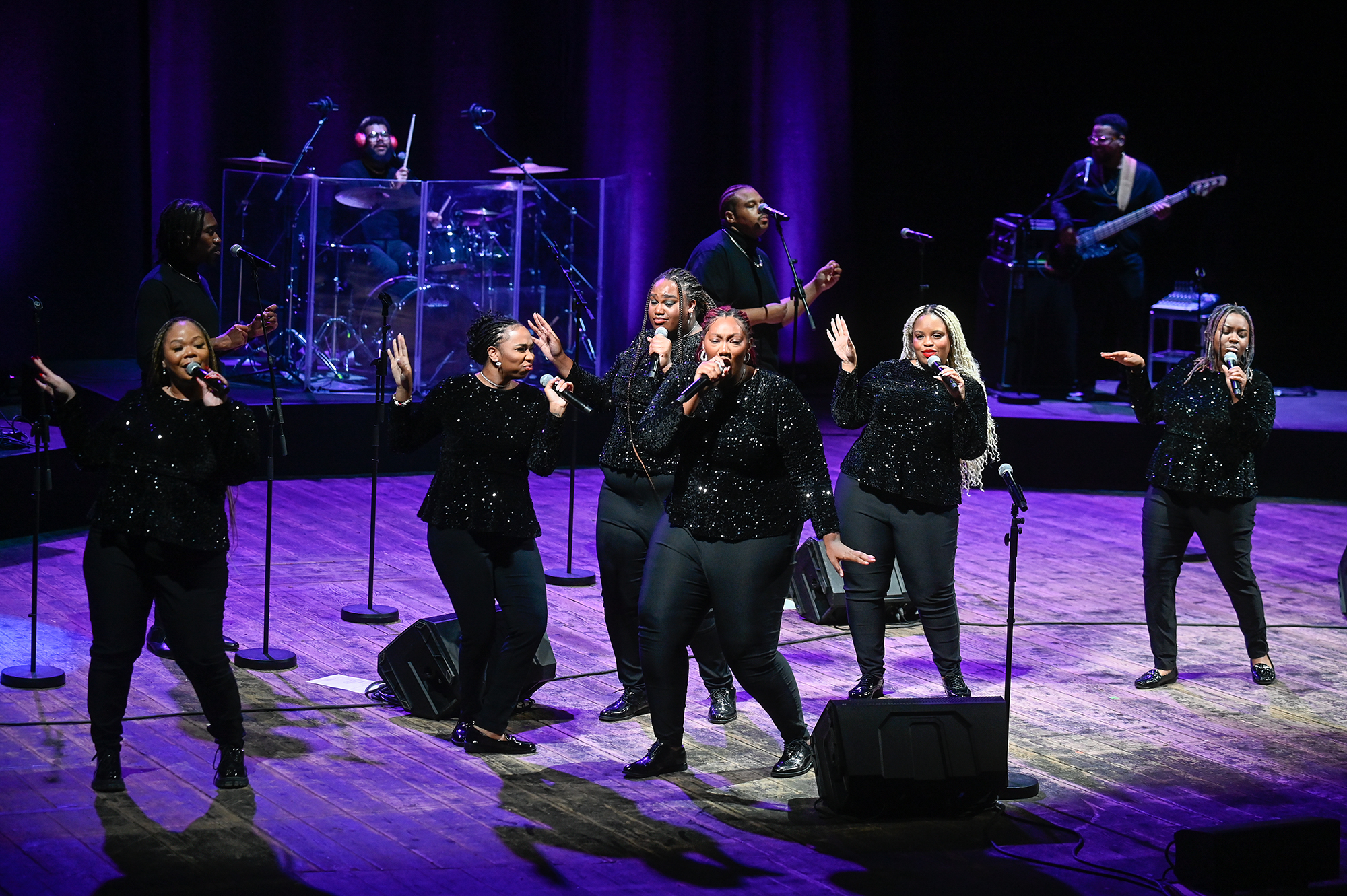 Festival di Spoleto performers singing in sparkling black outfits on dramatic purple stage