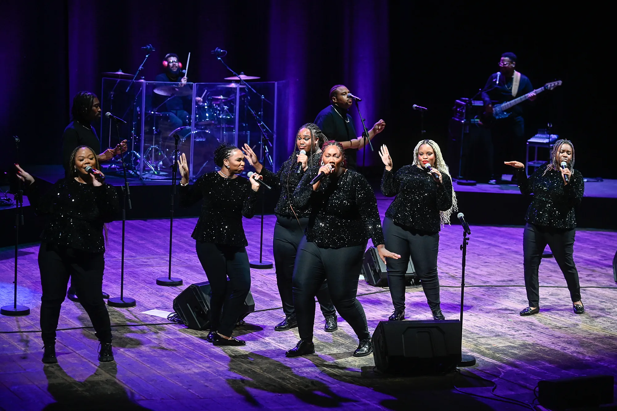 Festival di Spoleto performers singing in sparkling black outfits on dramatic purple stage