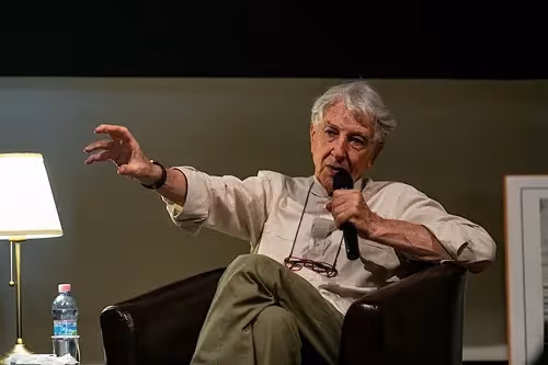 Anziano ospite gesticola durante un incontro al Festival di Spoleto