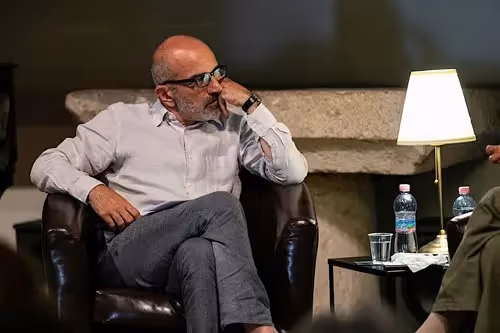 Ospite anziano al Festival di Spoleto, seduto pensieroso in poltrona