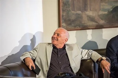 Elderly man smiling at Festival di Spoleto event during press conference