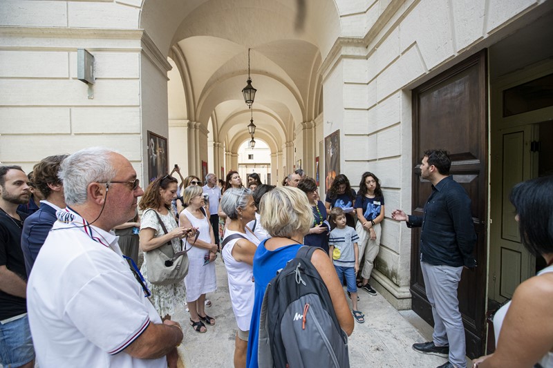 Crowds gather at Festival di Spoleto event in historic arched architectural corridor