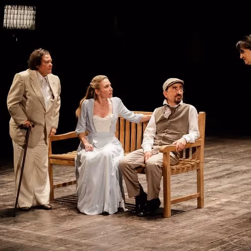 Scena teatrale al Festival di Spoleto con attori su panca in legno