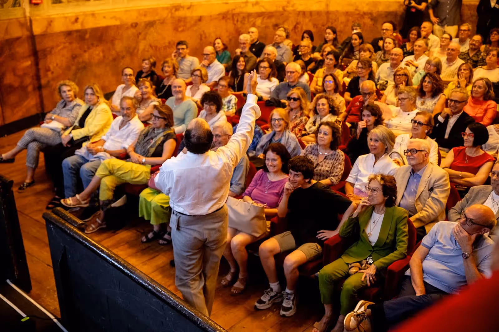 Pubblico numeroso al Festival di Spoleto, un relatore alza la mano