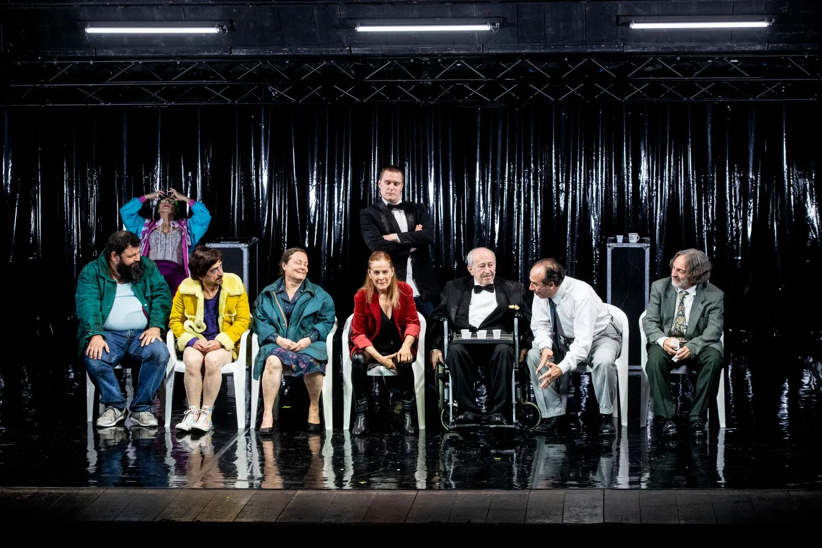 Scena teatrale colorata al Festival di Spoleto con attori seduti