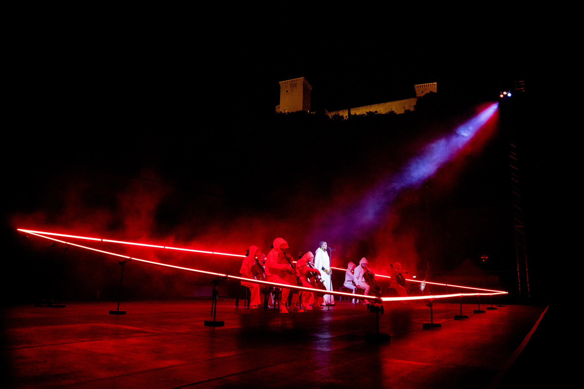 Festival di Spoleto performance with dramatic red stage lighting and medieval fortress