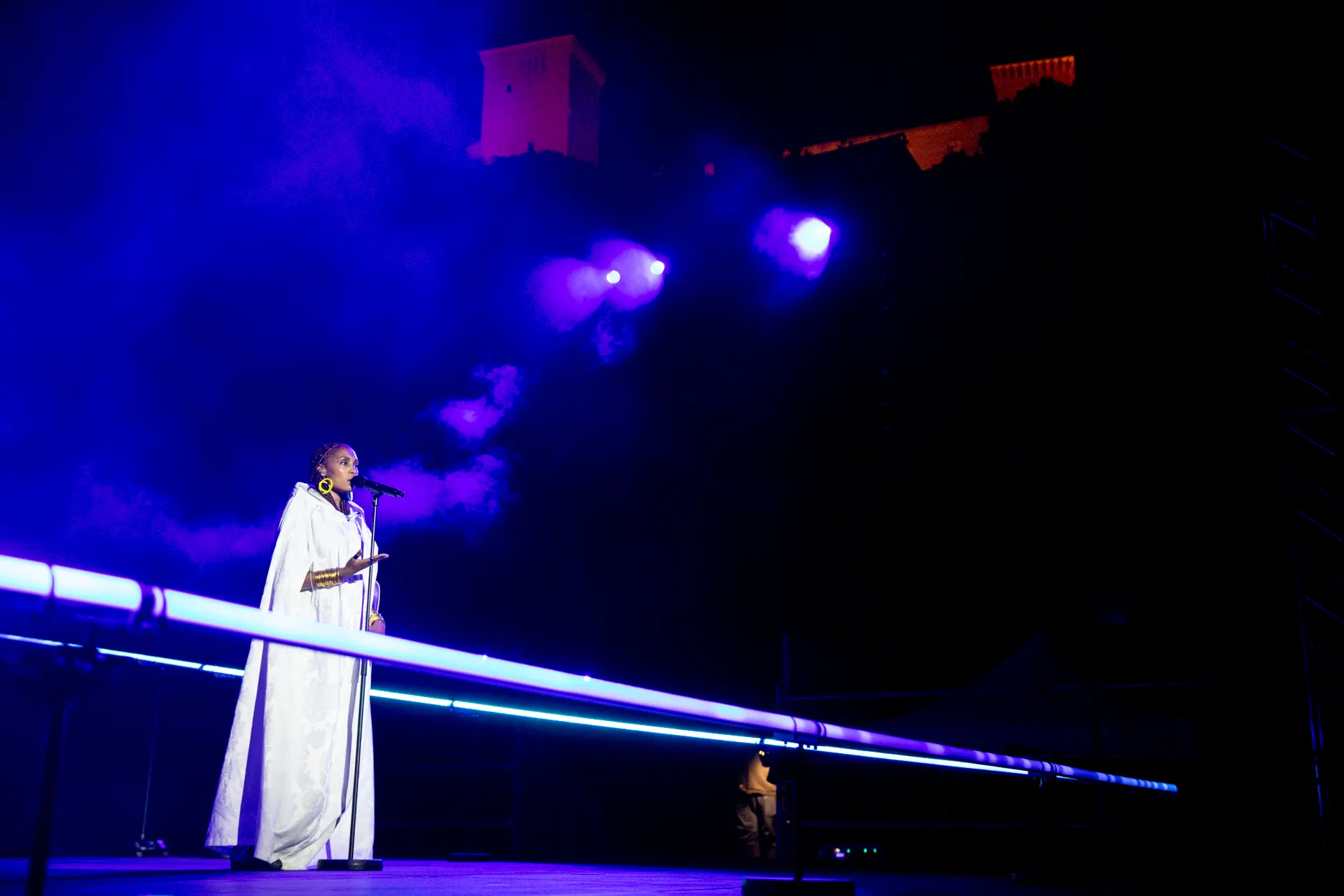 Artista in bianco si esibisce al Festival di Spoleto con luci blu e viola