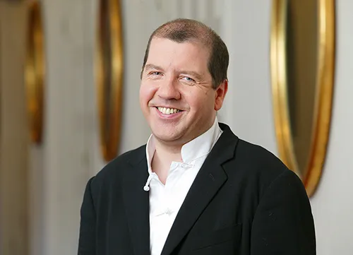 Smiling man at Festival di Spoleto event, wearing black jacket and white shirt