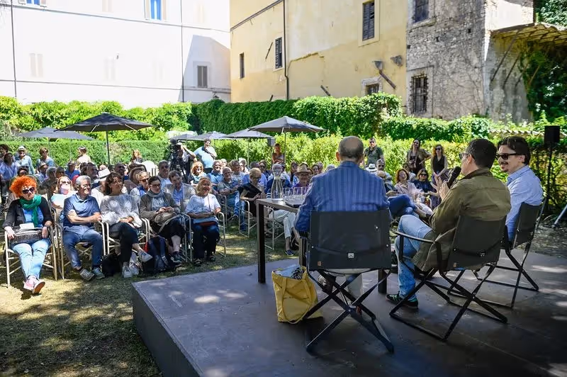 Festival di Spoleto outdoor event with audience seated under umbrellas in historic setting
