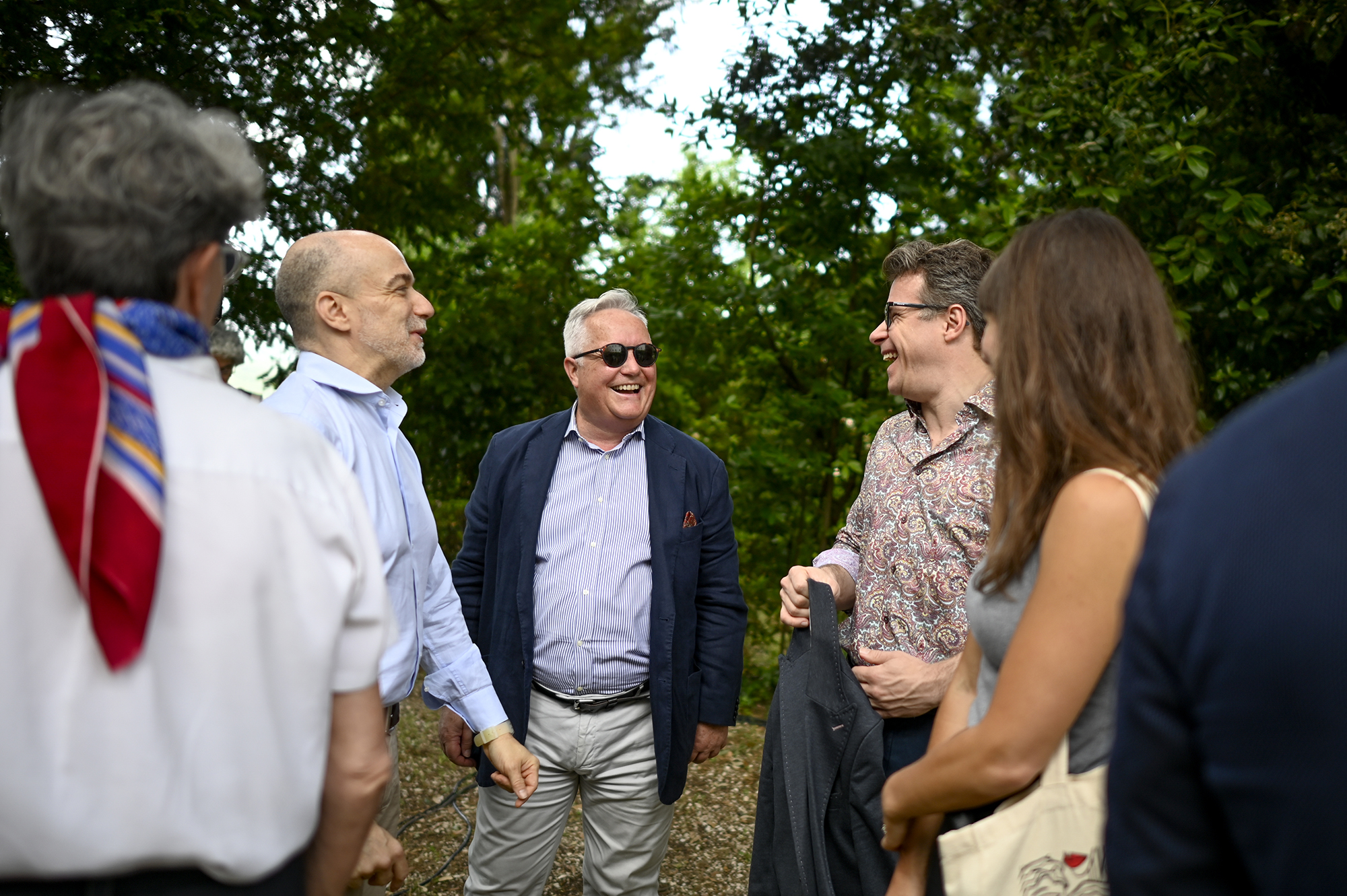 Festival di Spoleto attendees enjoying conversation in lush green setting