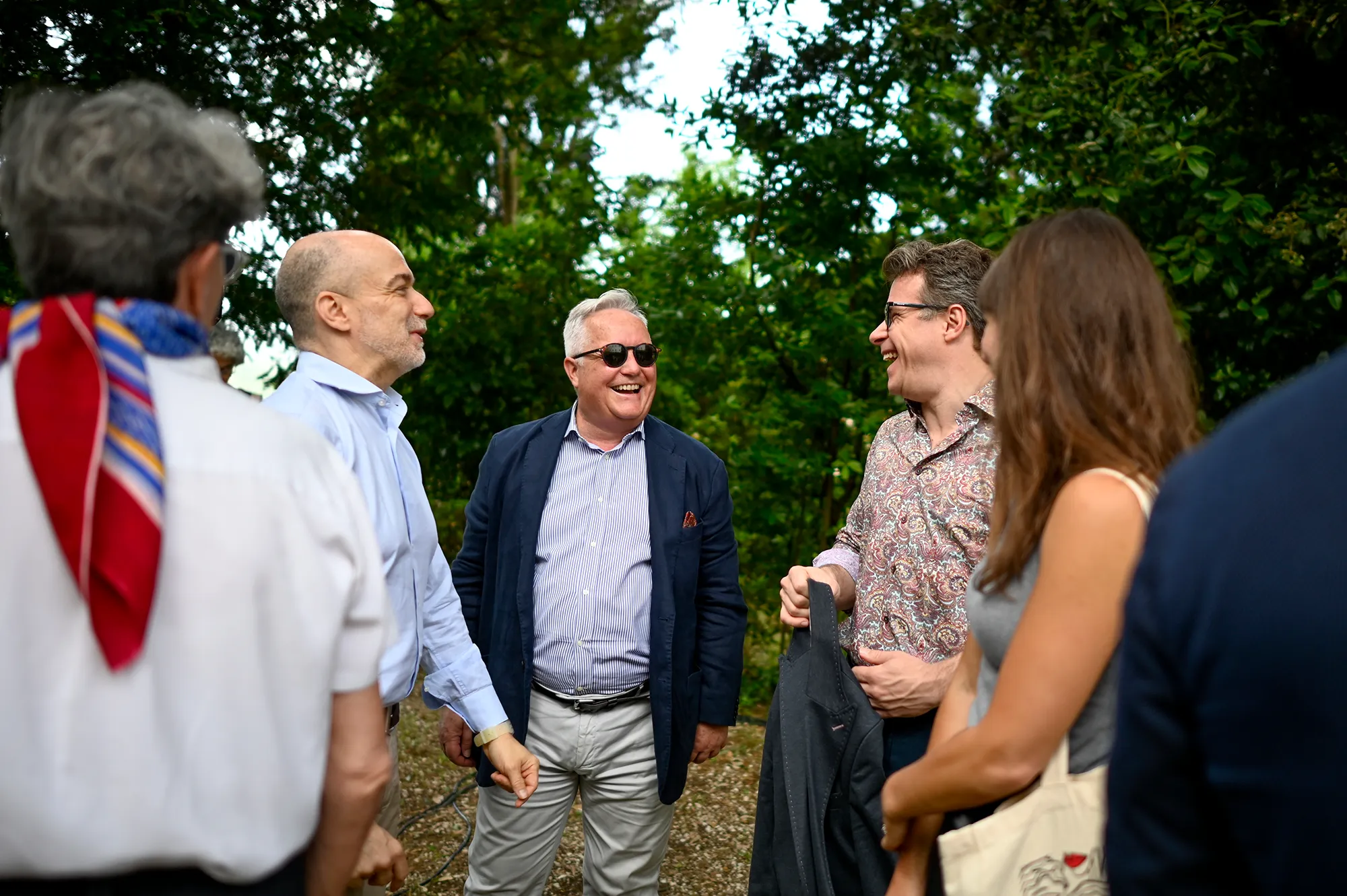 Festival di Spoleto attendees enjoying conversation in lush green setting