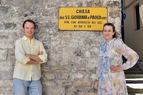 Due persone davanti alla Chiesa di Spoleto durante il Festival dei Due Mondi