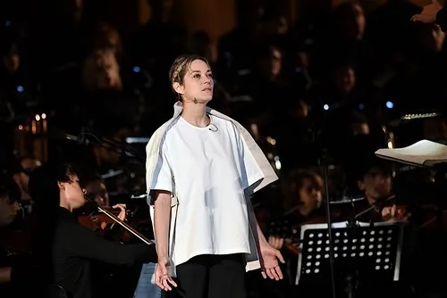 Performer on stage at Festival di Spoleto, standing before orchestra