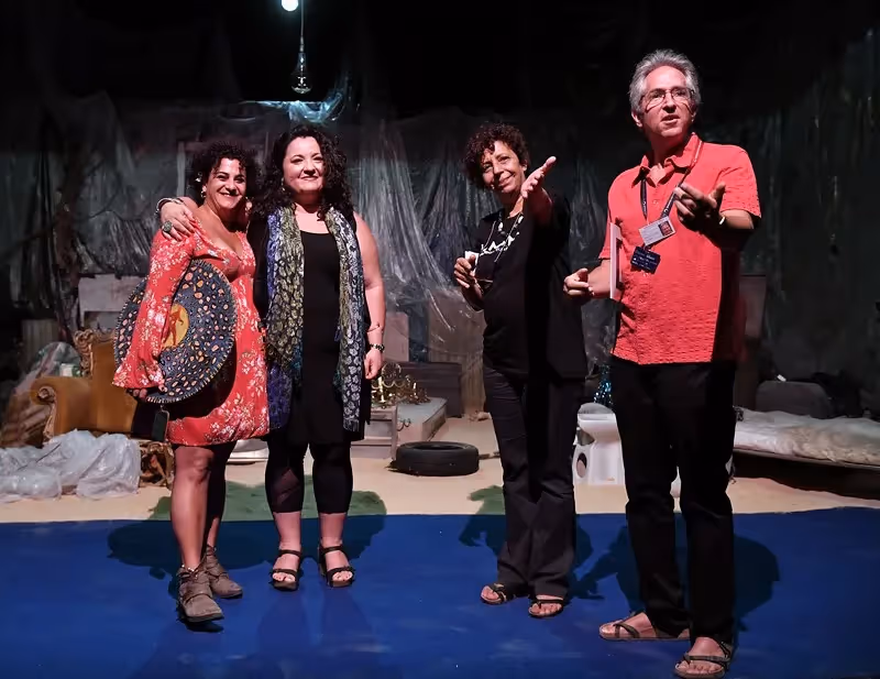 Quattro partecipanti sorridenti al Festival di Spoleto, in posa sul palcoscenico