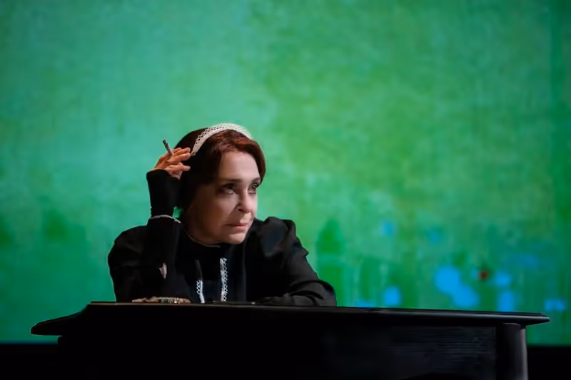 Performer on stage at Festival di Spoleto with contemplative green background