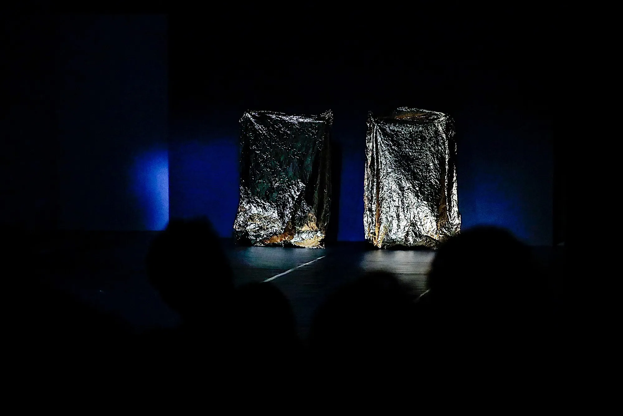Installazione artistica al Festival di Spoleto, oggetti metallici scintillanti nel buio
