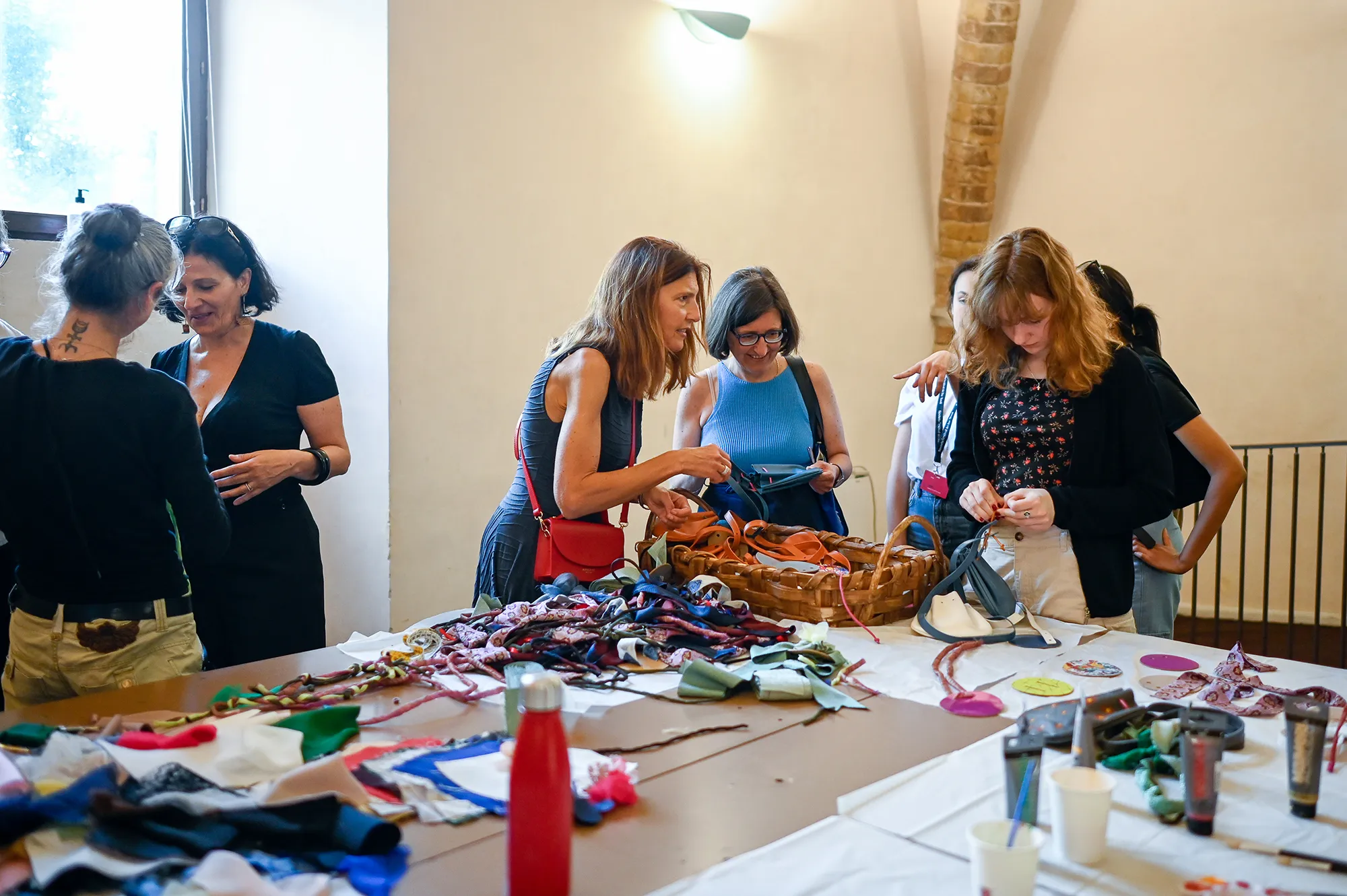 Laboratorio creativo durante il Festival di Spoleto con donne che lavorano a manufatti