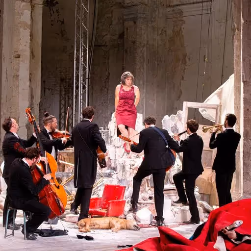 Performance artistica durante il Festival di Spoleto con musici e donna in rosso